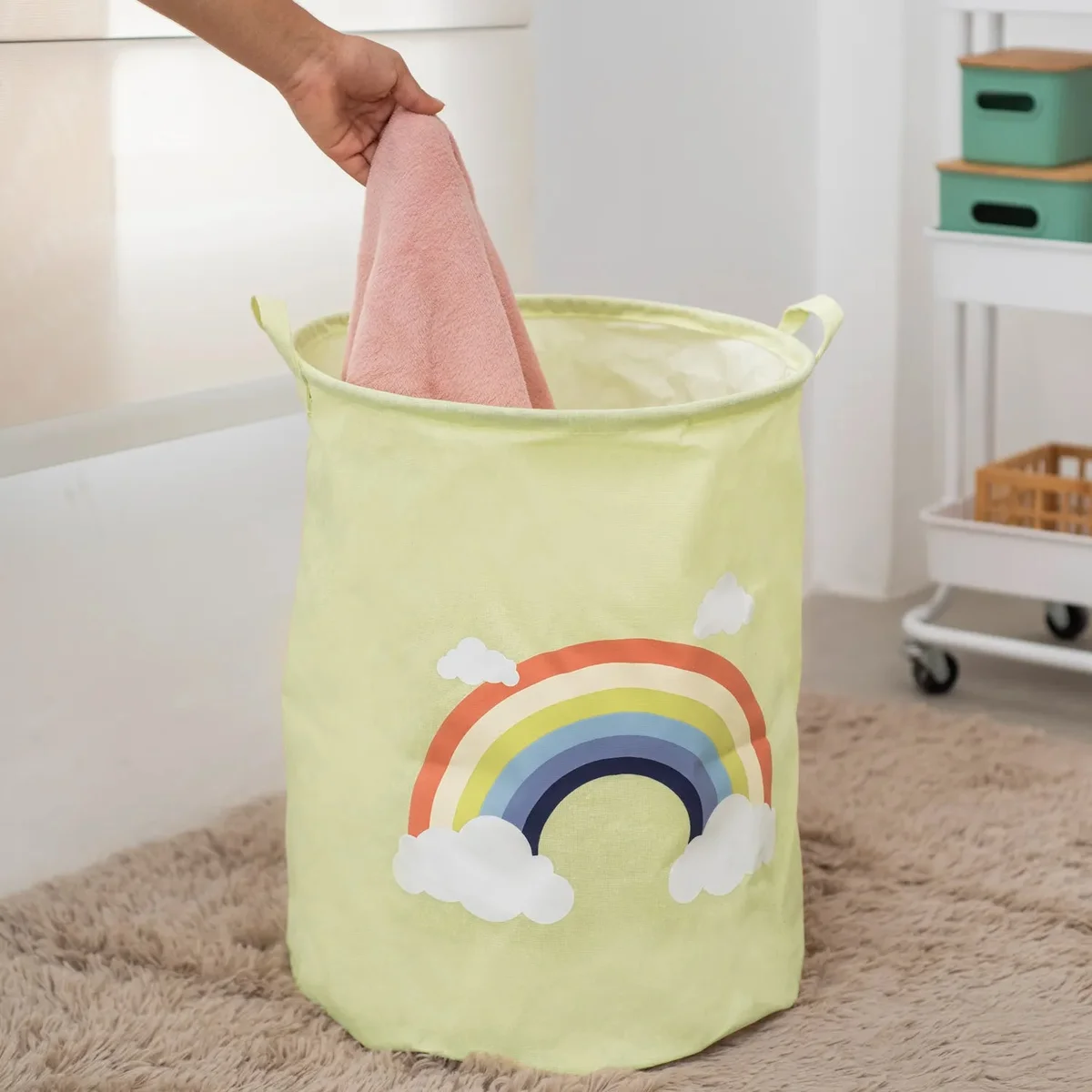 Two foldable portable laundry baskets with yellow, gray, and white zebra face design in a nursery room setting