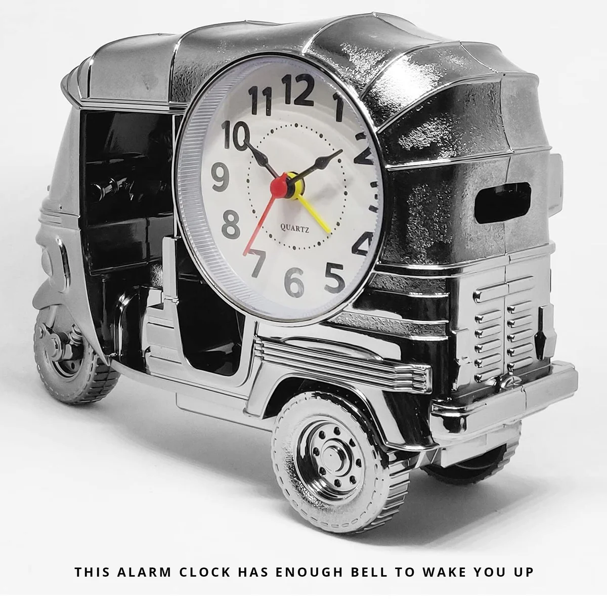 Modern three wheeler clock in plastic with analogue display, shown on a wooden desk in a bright room setting