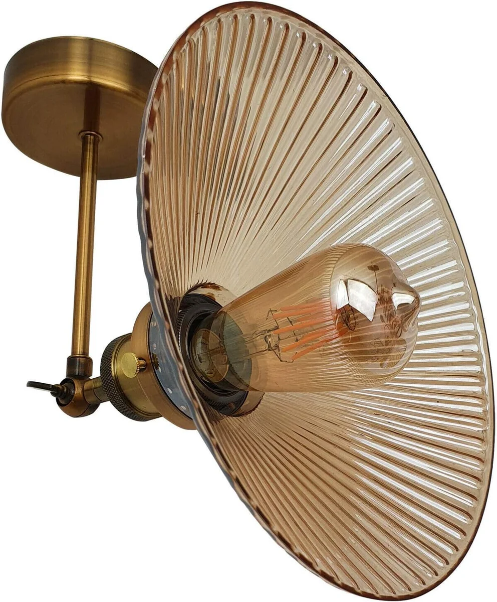 Vintage style wall light with amber ribbed glass shade, adjustable brass holder, and black metal arm mounted on wall