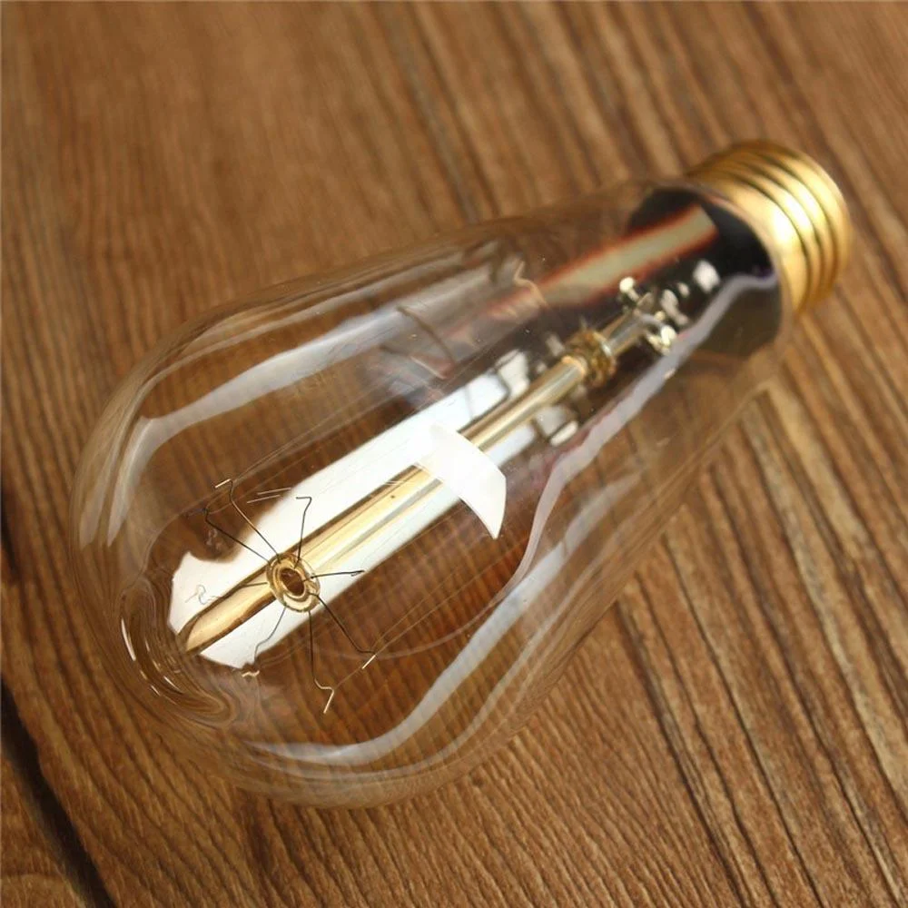 Ten vintage ST64 E27 warm white bulbs with visible filaments arranged on a wooden surface in soft lighting