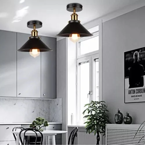 Black and yellow brass metal ceiling light with vintage cone shade mounted on white ceiling over kitchen sink