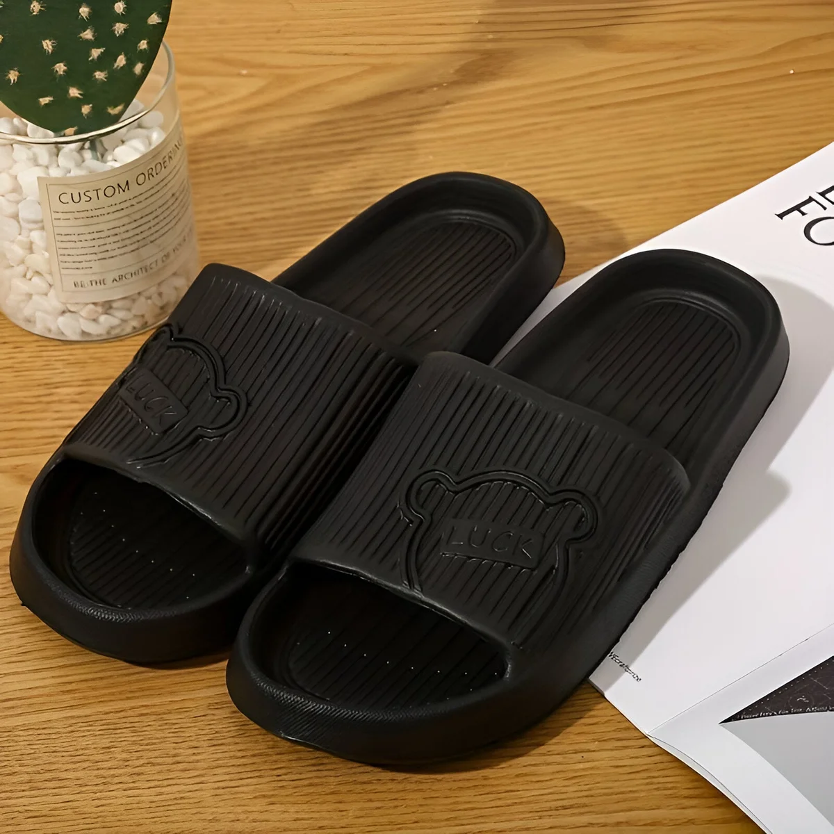 Pair of unisex lightweight flip flops in black with ergonomic design and non-slip EVA soles for indoor and outdoor use