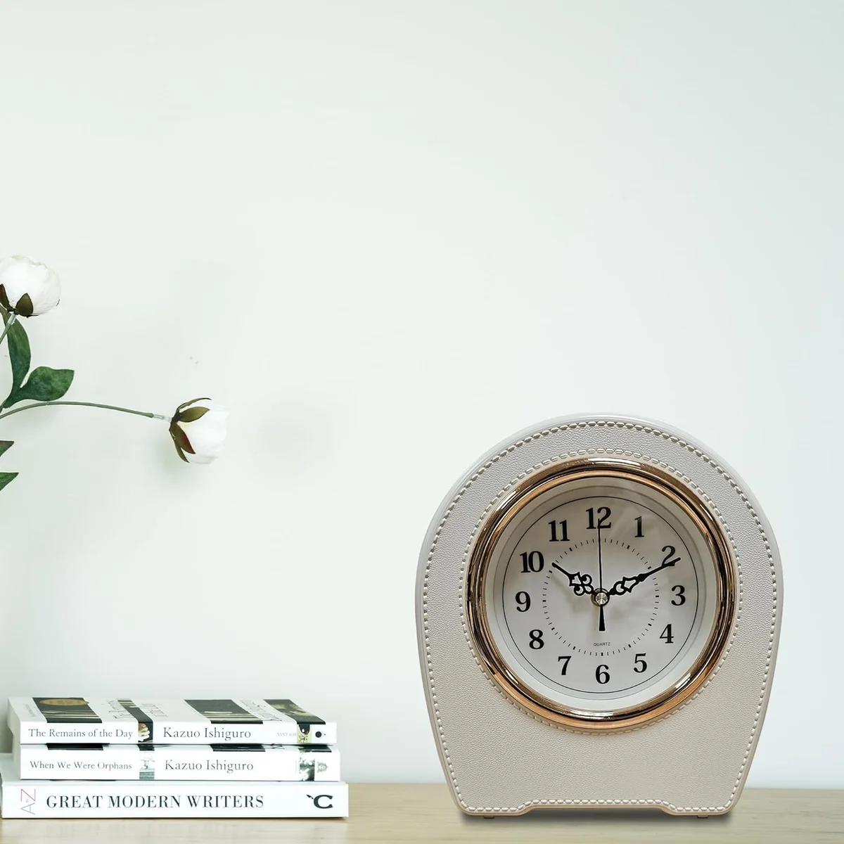 Small mantel clock with vintage leather finish, black color, rectangular shape, displayed on a wooden table indoors