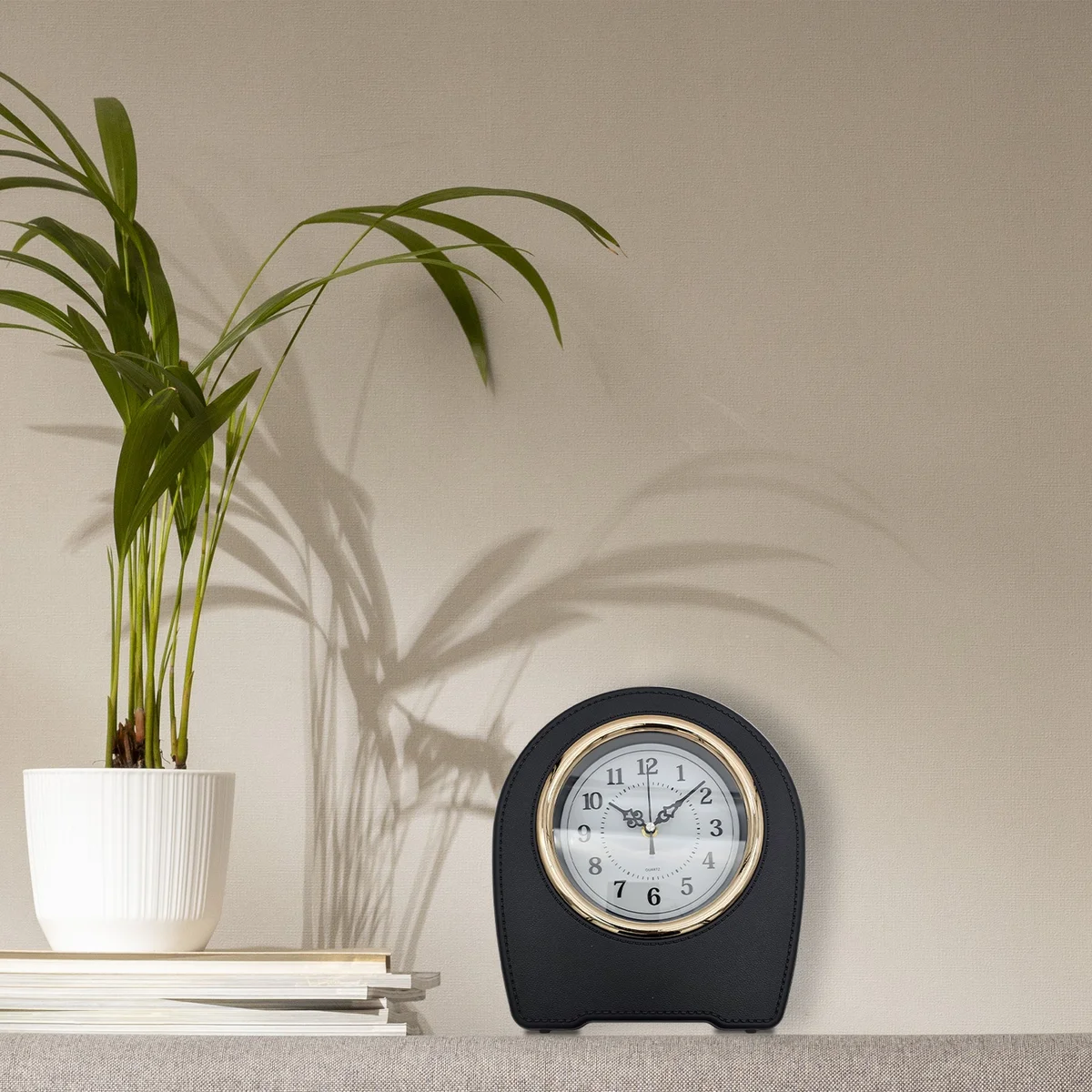 Vintage style clock with leather finish, black face, and white numerals on a living room wooden table display