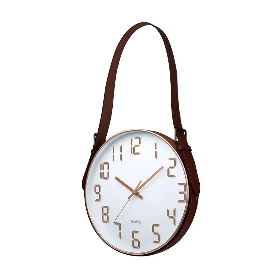 Modern wall clock with round concrete face and brown leather strap hanging on a white wall, showing sleek design details