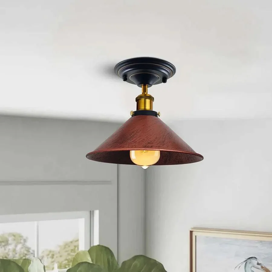 Industrial pendant light with metal cone shade, brass and copper accents, housed in a rustic style ceiling fixture.