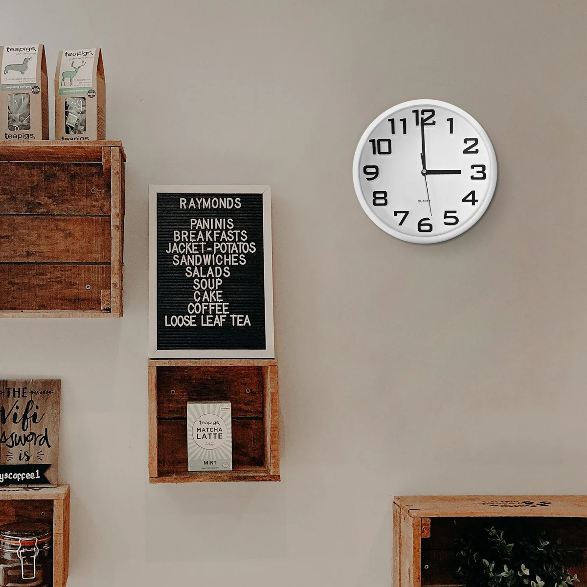 Minimalist round white quiet kitchen clock with clear black numbers and hands on a sleek plastic surface, battery powered