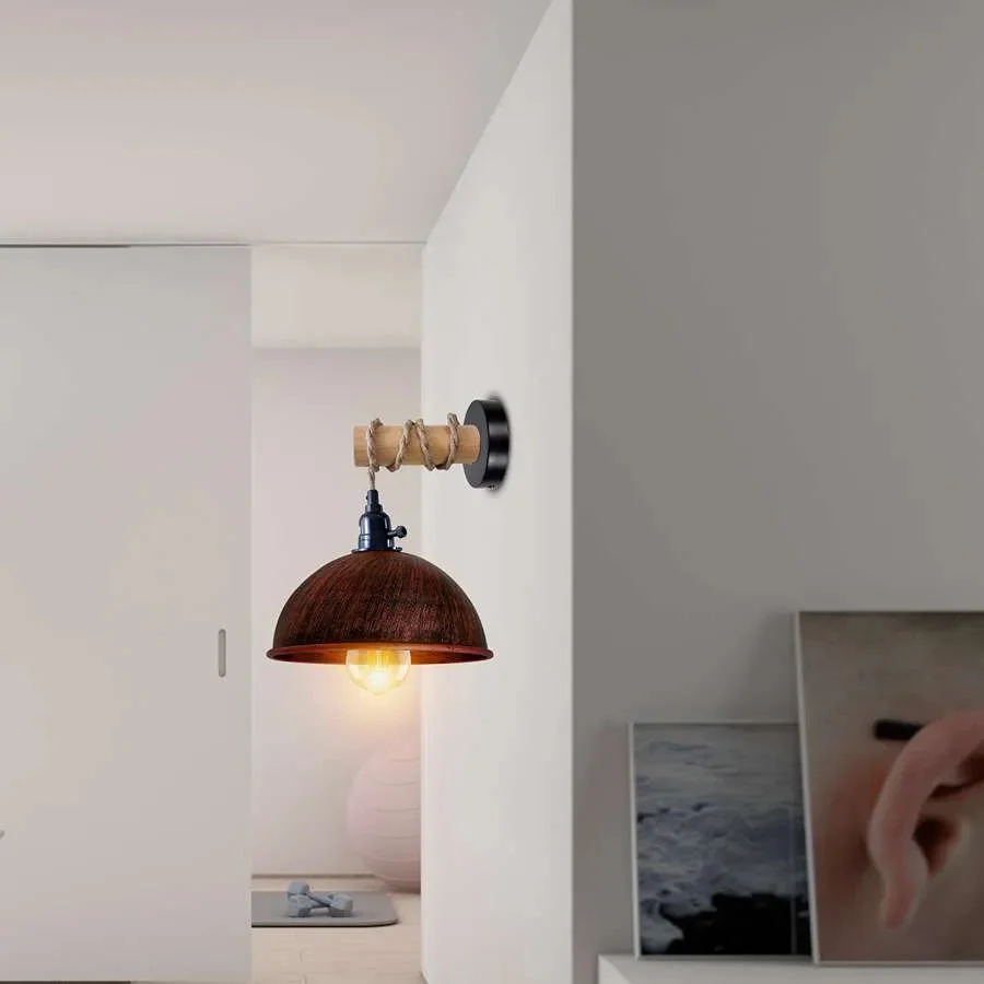Vintage industrial wall light with wooden arm and metal dome shade hanging against a neutral background