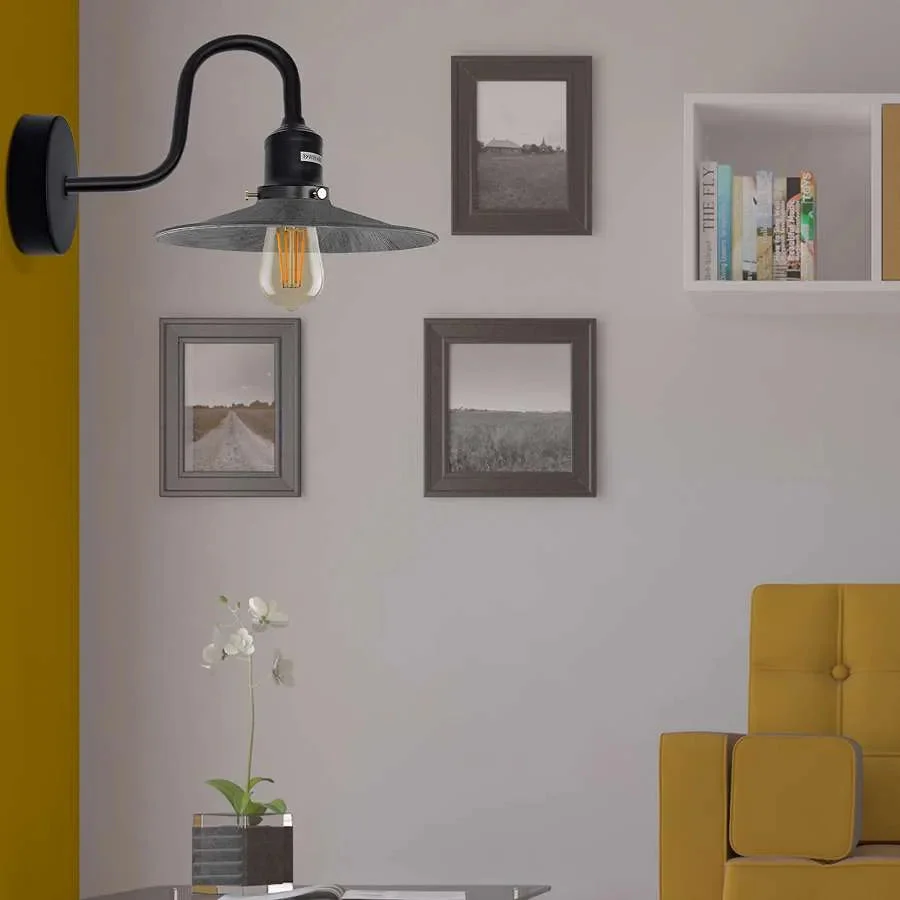 Metal vintage wall lamp with curved swan neck arm and E27 bulb holder mounted on a white wall background