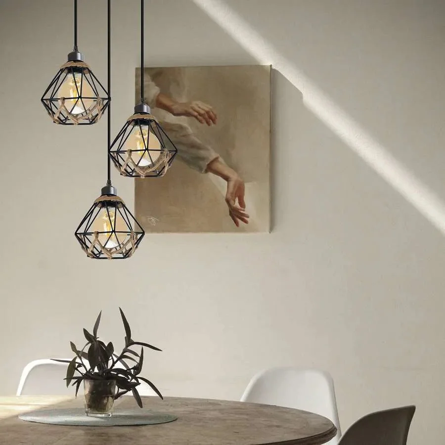 Three metal cage E27 bulb pendant lights with adjustable hemp rope cables hanging from ceiling rose in industrial style