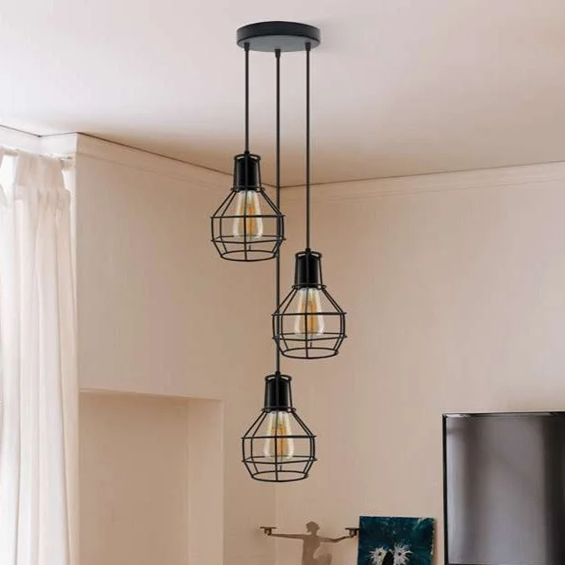 Black industrial pendant light with three metal cage shades hanging from adjustable cable ceiling mount
