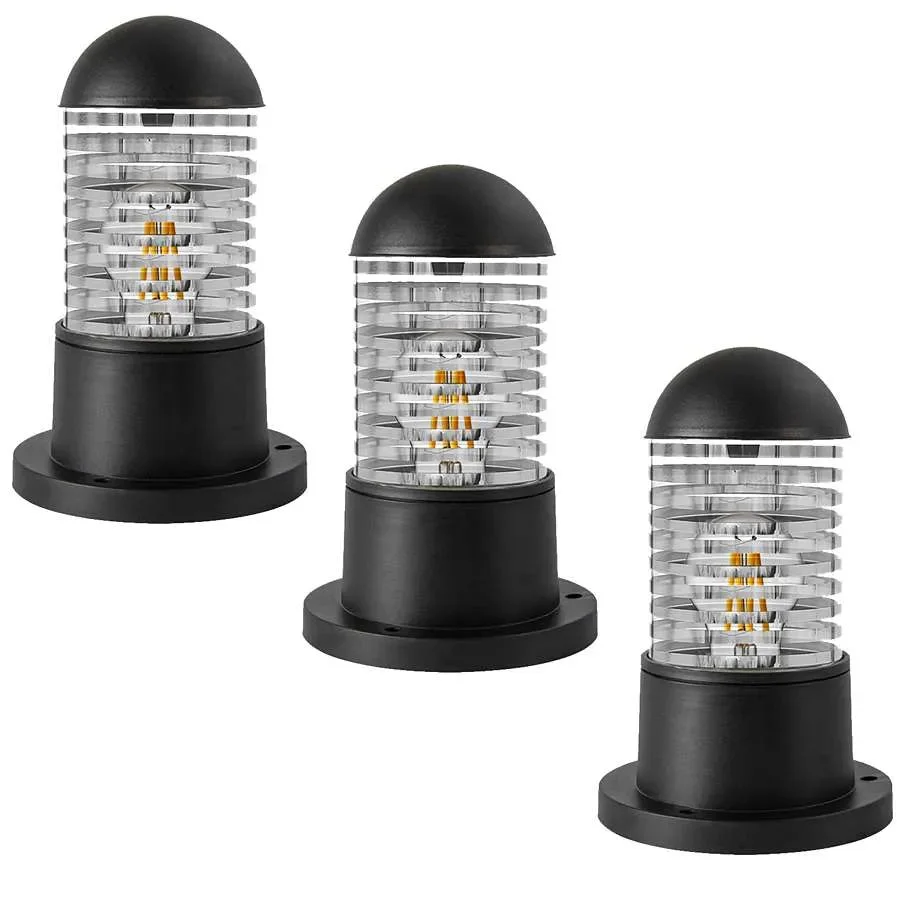 Modern black outdoor bollard light with cylindrical glass shade mounted on a garden post, suitable for exterior use