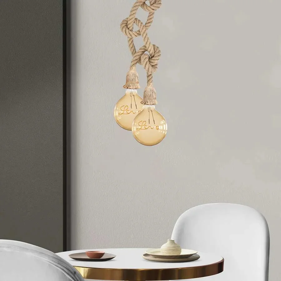 Modern hemp rope pendant light hanging above wooden table, showcasing adjustable knots and warm bulb glow in cafe setting