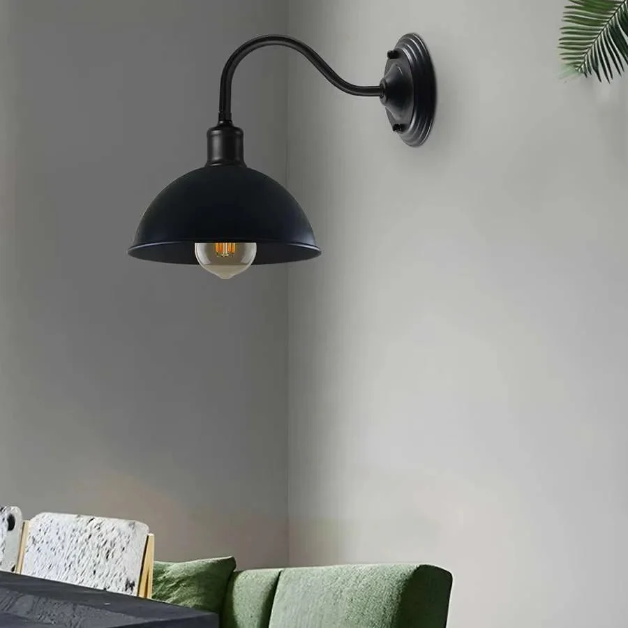Industrial swan neck metal dome wall light with curved arm and wide dome shade mounted on white wall background