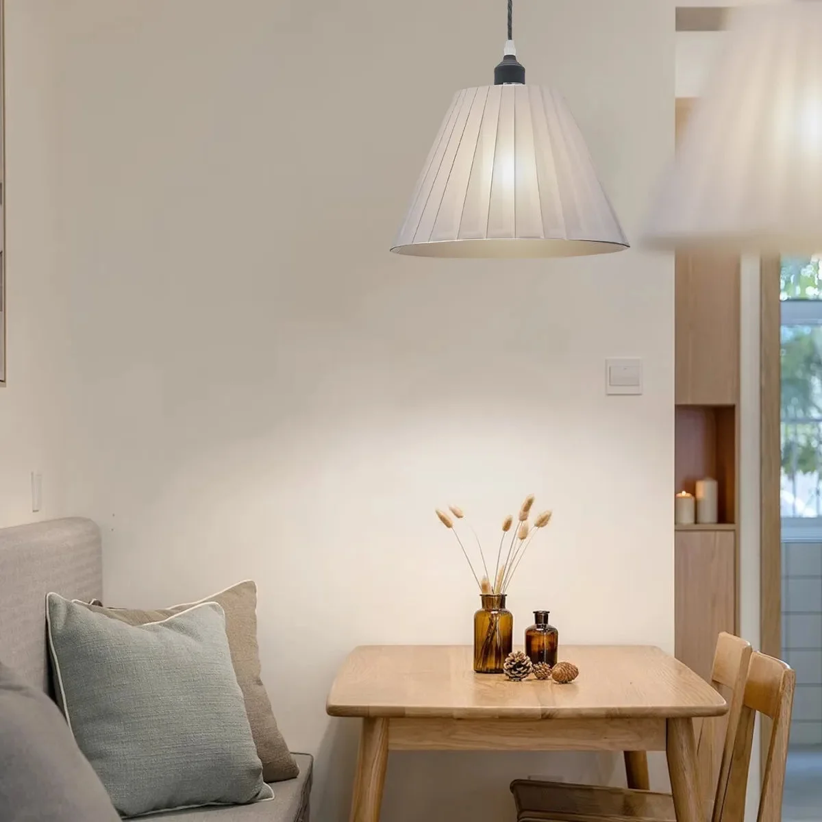Modern pendant light with white pleated metal fabric lampshade hanging from ceiling, suitable for indoor decor
