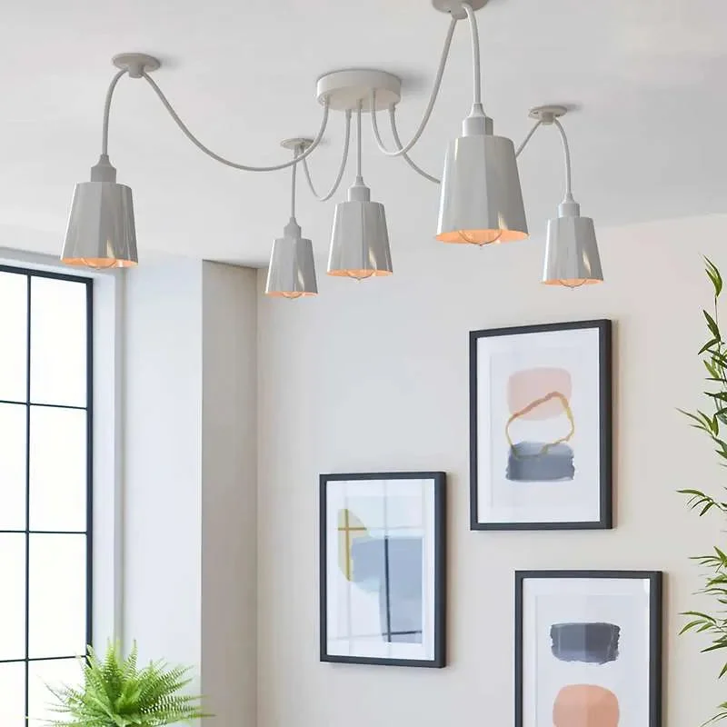 White 5-arm adjustable ceiling light with matte cone shades and fabric-wrapped cables in a modern industrial style