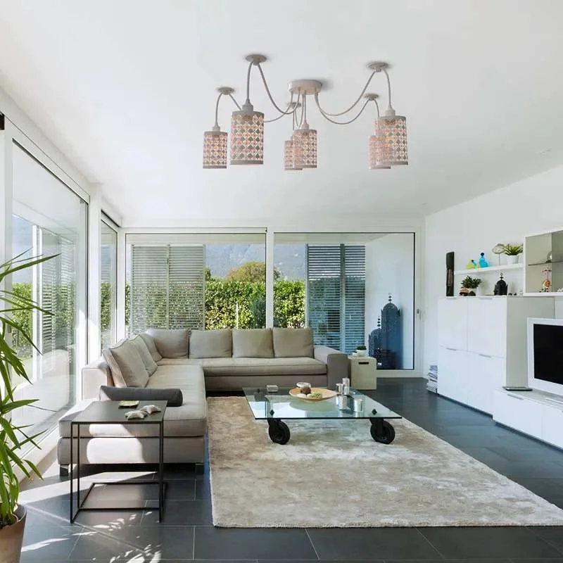 White 6 way spider ceiling light with adjustable fabric-covered cables and metal wire cage shades hanging from ceiling plate