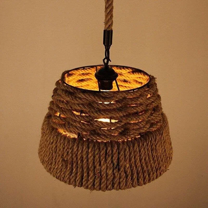 Industrial hemp rope pendant light with metal cage shade hanging against plain background, vintage rustic style