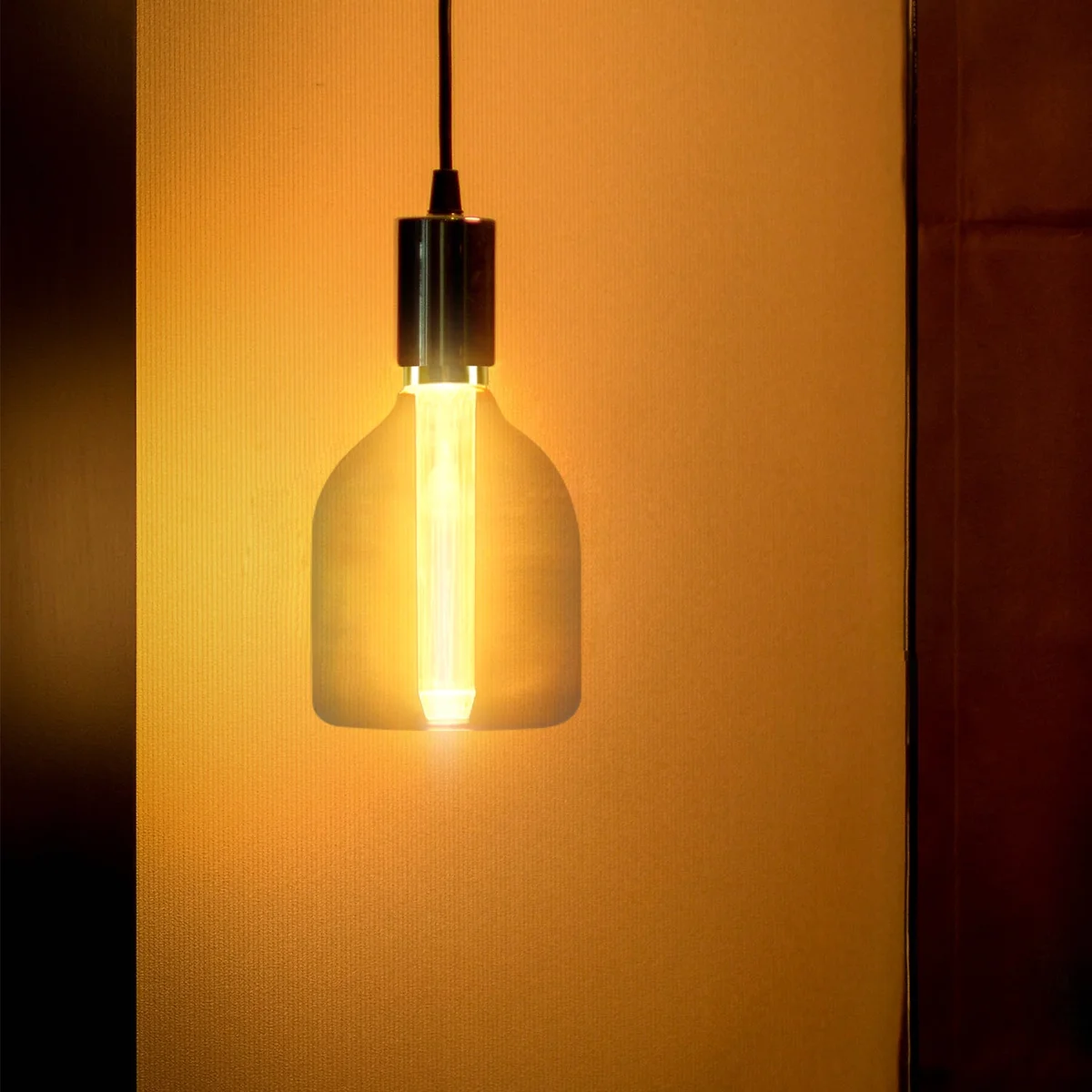 Vintage amber glass E27 LED bulb with exposed filament glowing warm 2000K light, 3W energy-saving design