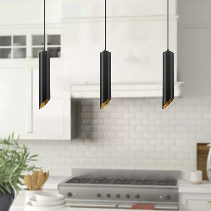 Black gold pendant light with long cylindrical black matte exterior and gold interior, hanging with adjustable black cable