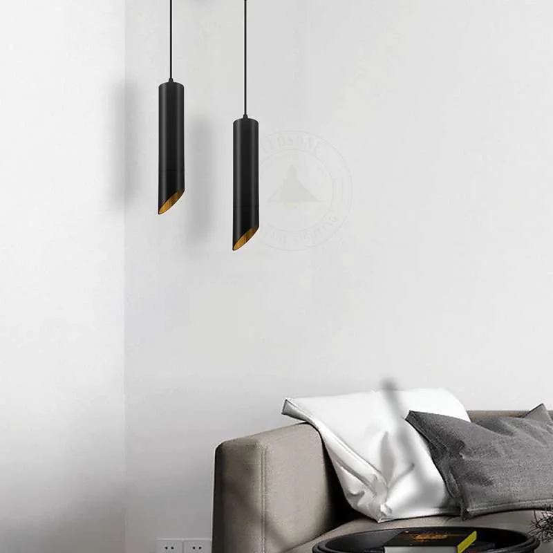 Black gold pendant light with matte black exterior and gold inner tube shade, hanging from adjustable black cable