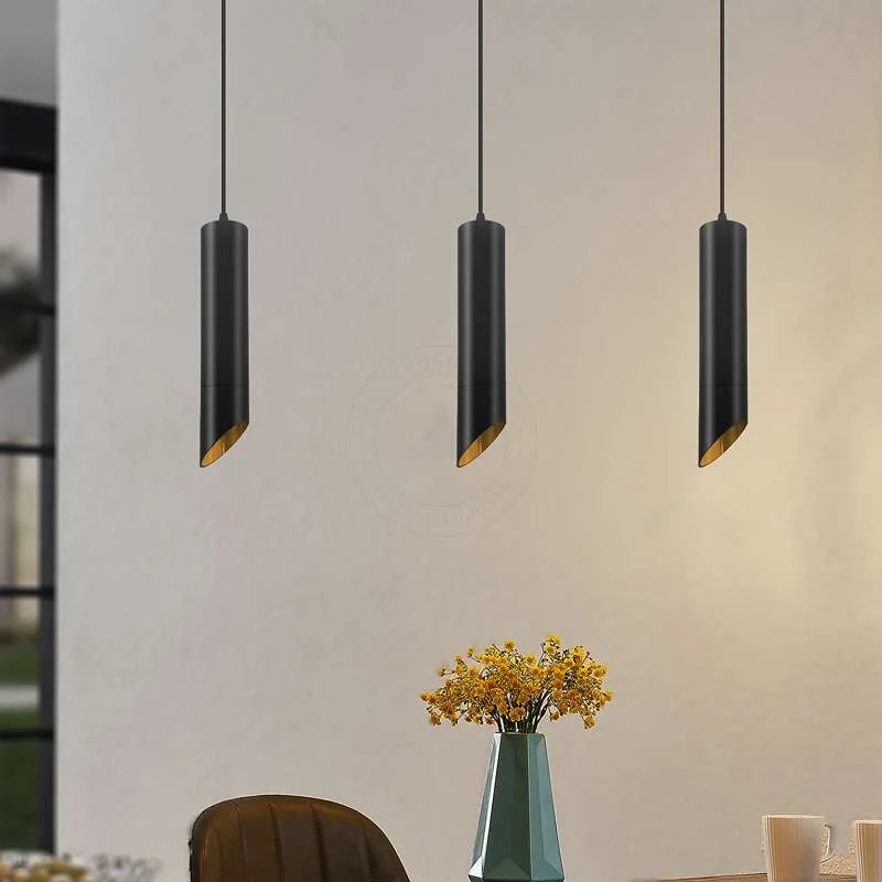Black gold pendant light with long cylindrical tube shade, matte black exterior and gold inner finish hanging from ceiling