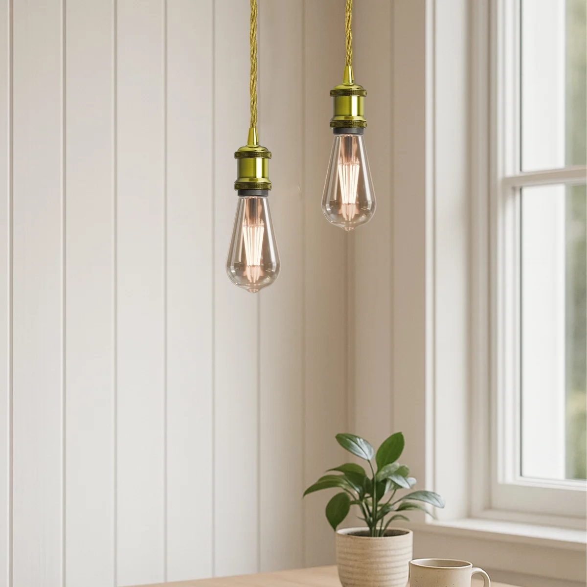 Gold twisted cable pendant light with yellow brass E27 holder and matching ceiling rose on white background