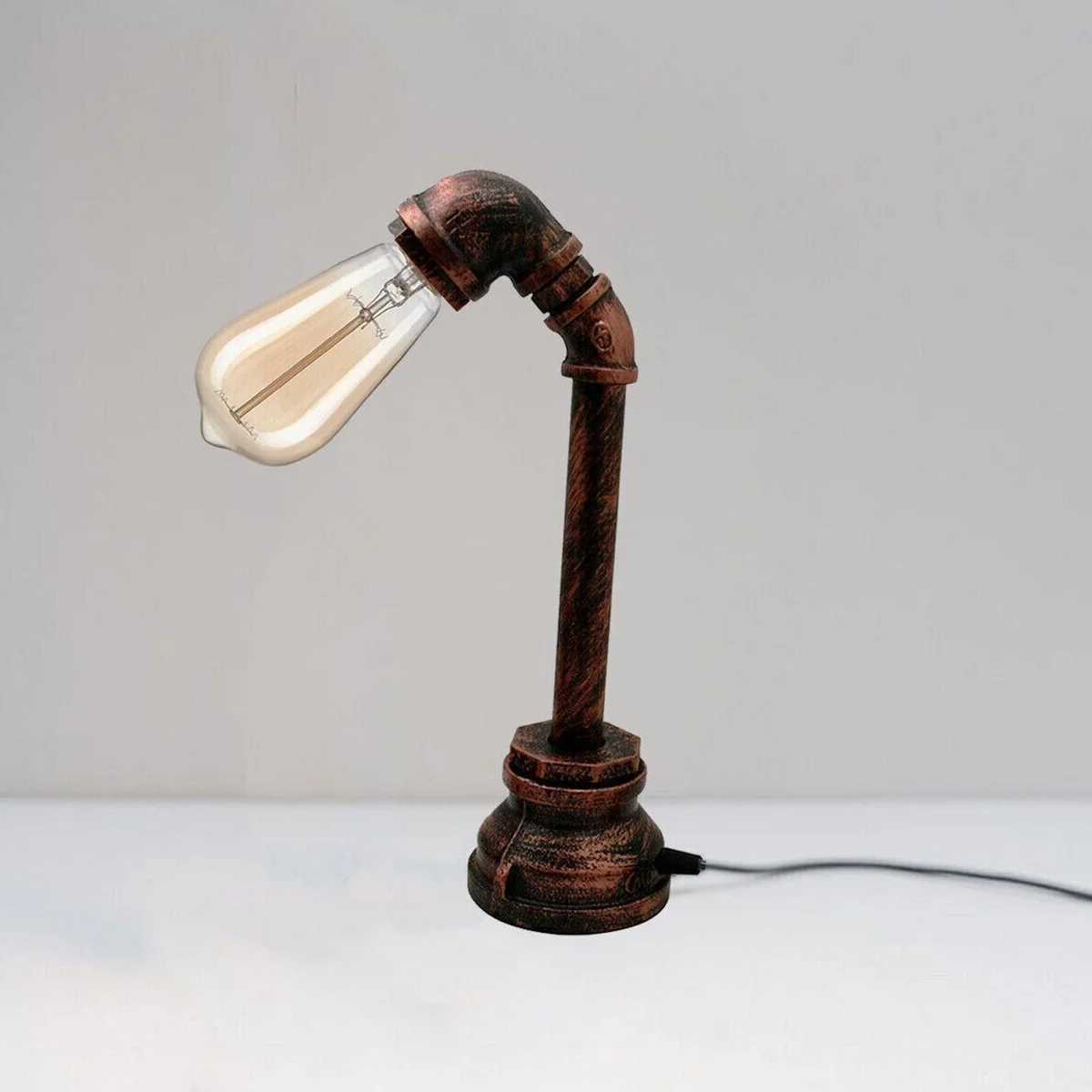 Vintage steampunk desk lamp with antique brass water pipe design and brushed copper finish on wooden surface