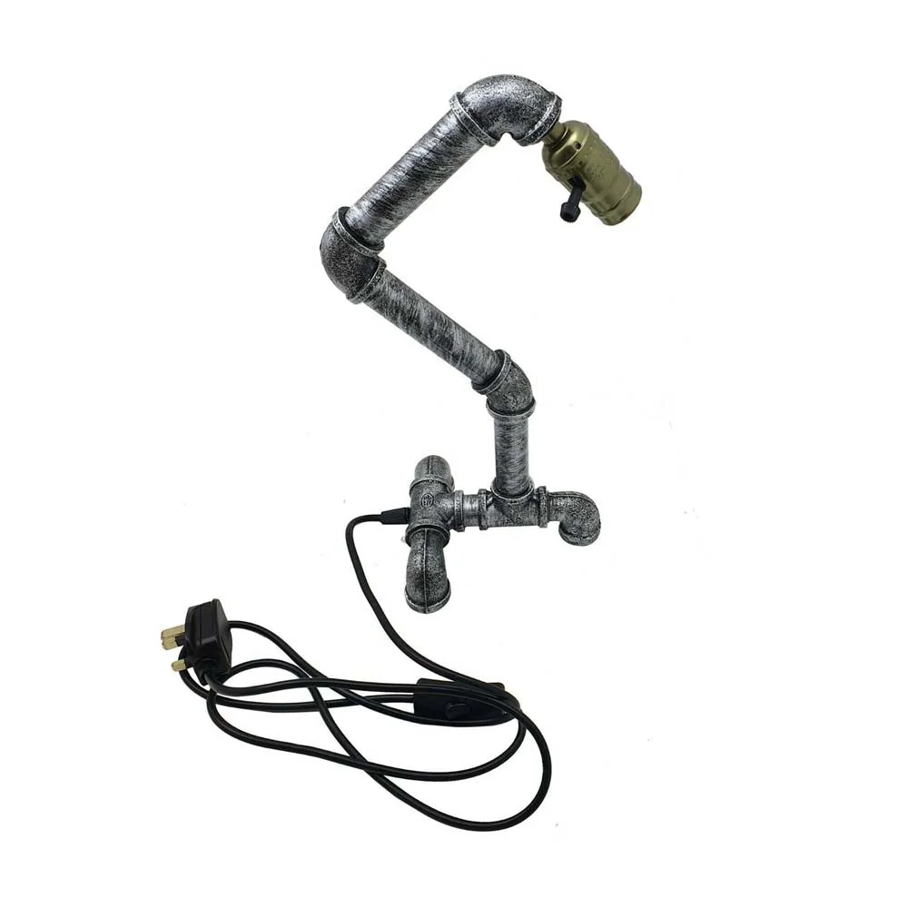 Industrial steampunk table lamp made of rust-resistant metal with water pipe design and compact base on a wooden surface