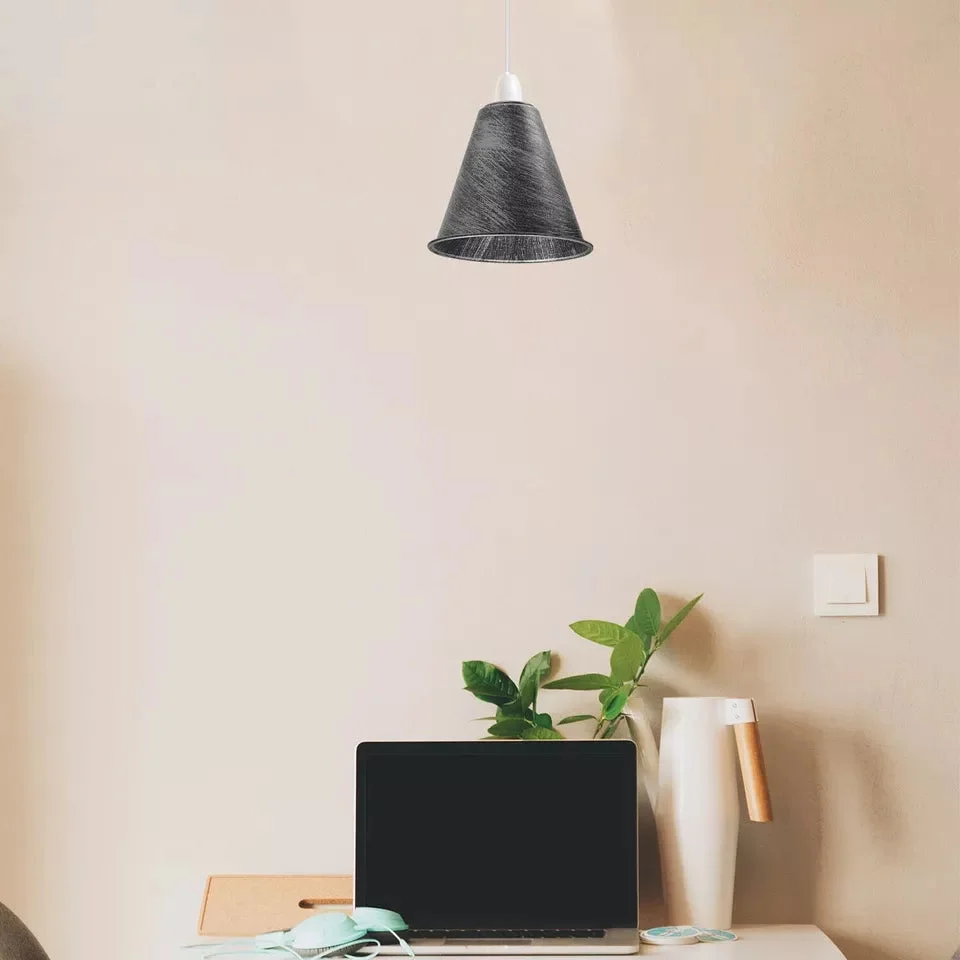 Black cone industrial style lampshade with brushed metal finish hanging from ceiling pendant light fitting