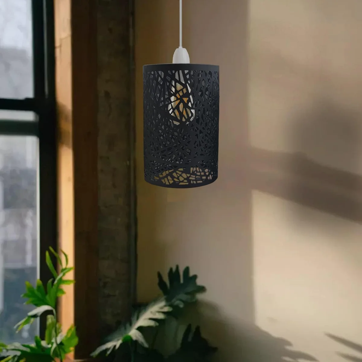 Brushed brass metal wire cage lampshade with open wire design, hanging from ceiling.