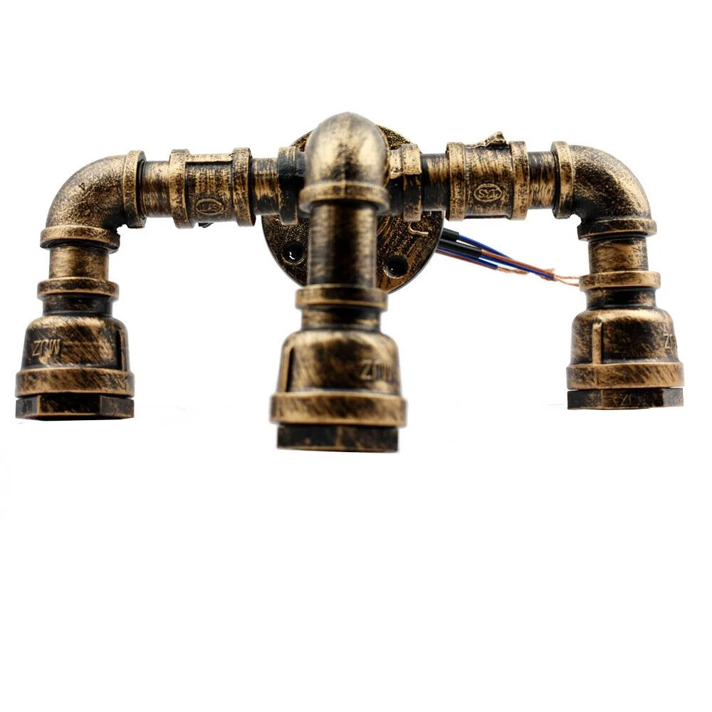 Brushed copper pipe lamp mounted on wall with exposed bulb in loft-style indoor setting, vintage metal finish