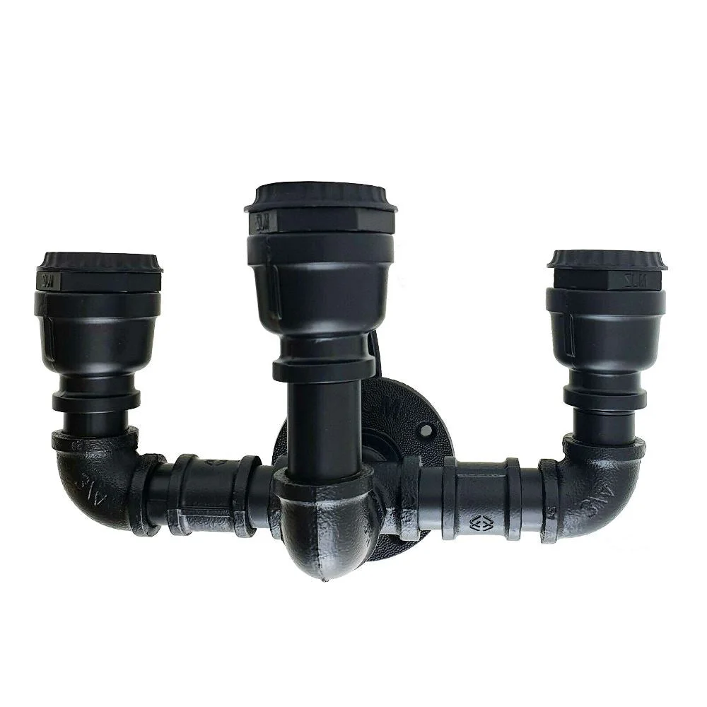 Steampunk wall light with three exposed Edison bulb sockets on black cast iron industrial pipe fixture against white wall