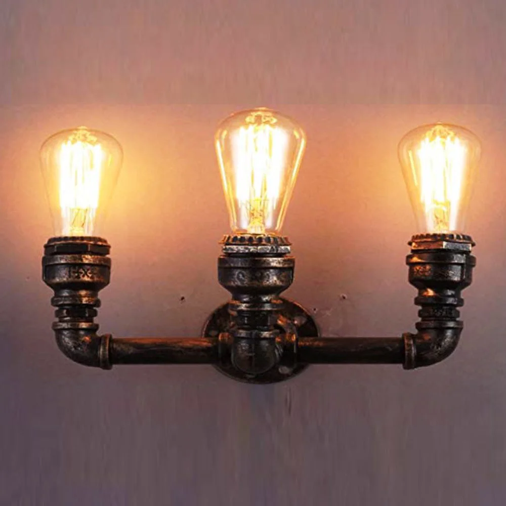 Steampunk wall light with three exposed Edison bulb fittings on cast iron pipes in matte black finish mounted on wall