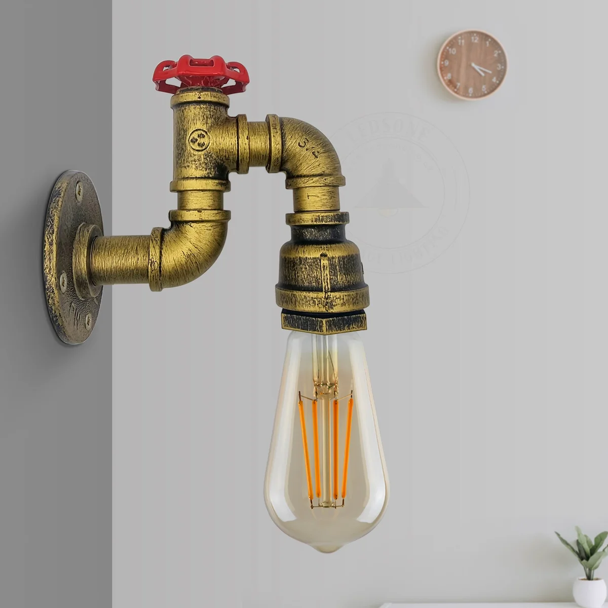 Vintage industrial water pipe wall light with metal wire cage shade and red valve on black pipe fitting