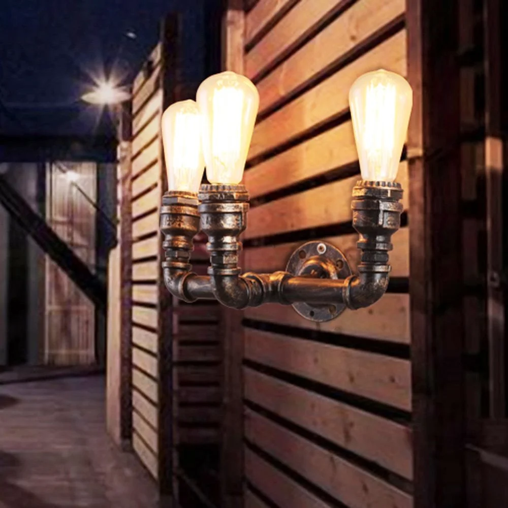 Brushed silver industrial wall light with three E27 lamp holders in a retro steampunk water pipe design on a wall