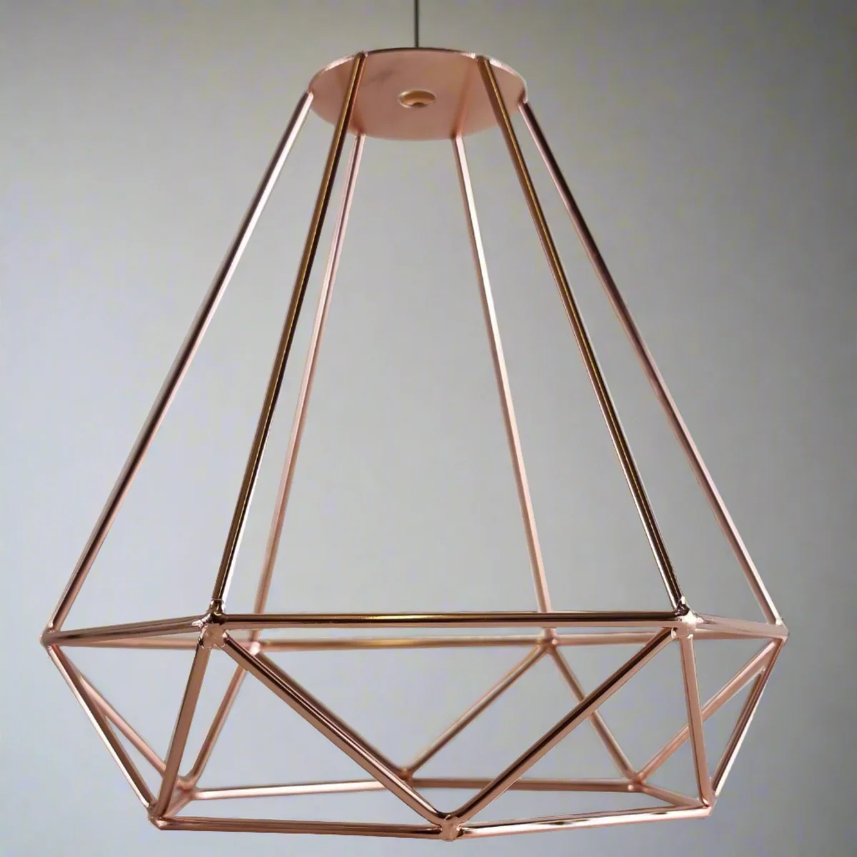 Black metal diamond wire cage easy fit lamp shade hanging from ceiling light socket against white background
