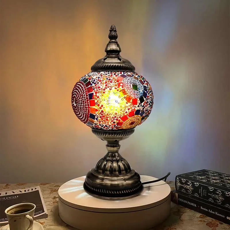 Turkish mosaic table lamp with colorful glass tiles and antique brass base, glowing warmly on a side table