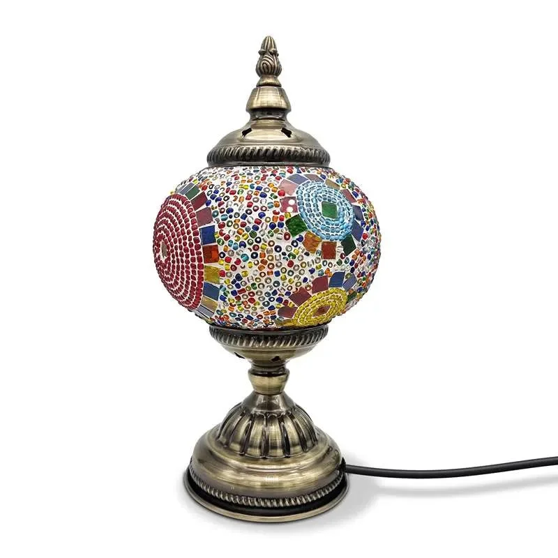 Turkish mosaic glass E27 bulb lamp with colorful tiles and antique brass base glowing on wooden side table