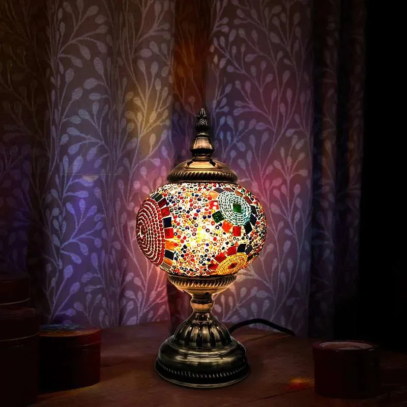 Turkish mosaic bedside table lamp with colorful glass tiles and antique brass base on wooden surface