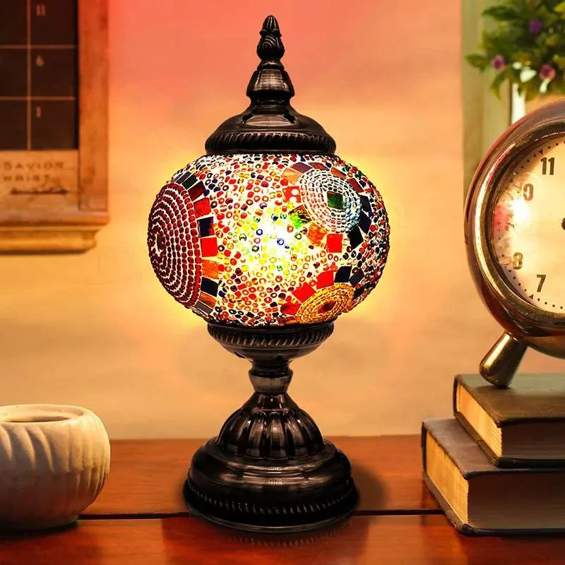 Turkish mosaic table lamp with colorful glass tiles and antique brass base, shown lit on a wooden side table
