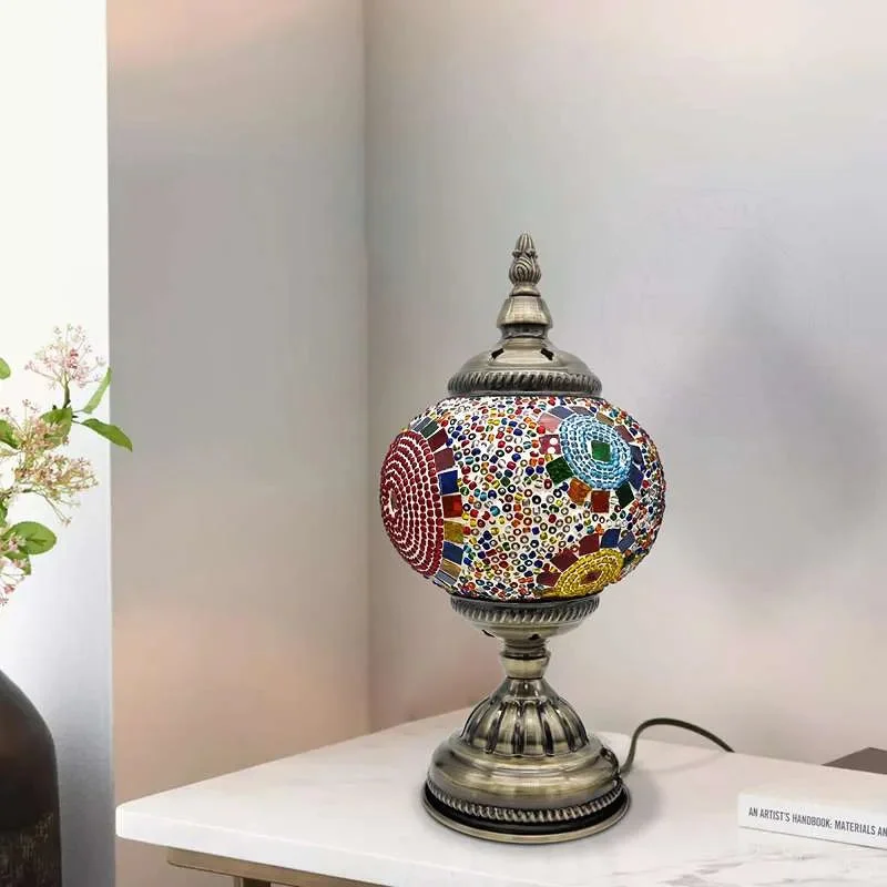 Turkish mosaic table lamp with colorful glass tiles and antique brass base on wooden side table in cozy room setting