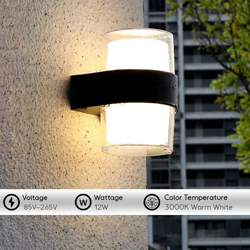 Black modern outdoor wall light with dual up and down warm white LED illumination on a garden wall at night