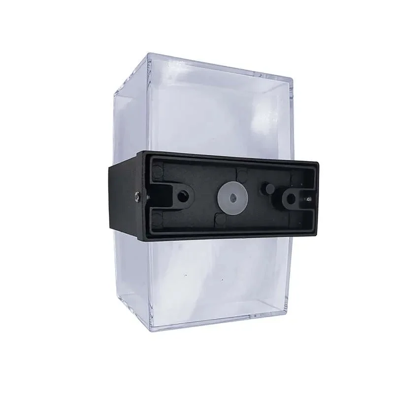 Black and white cuboid up down wall light mounted on exterior wall, showing warm LED light glow from top and bottom