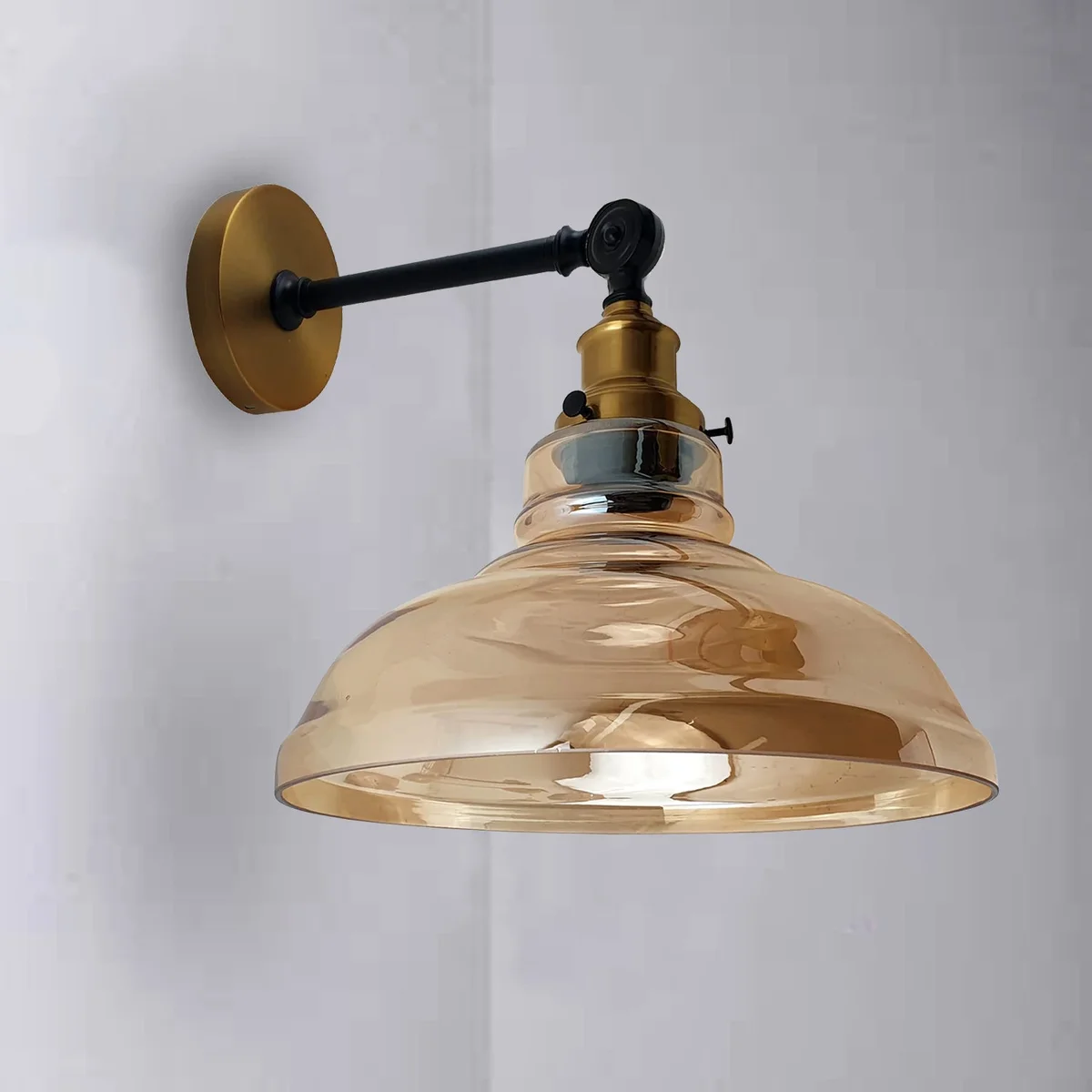 E27 amber glass wall light with metal fittings, casting a warm, inviting glow in an industrial style.