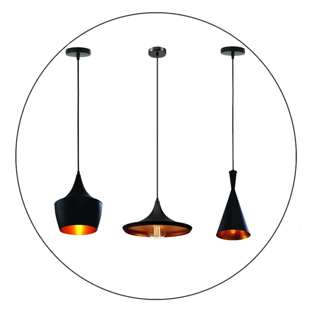 Industrial pendant light with matte black housing and hammered gold interior, hanging from PVC cable, casting amber glow.