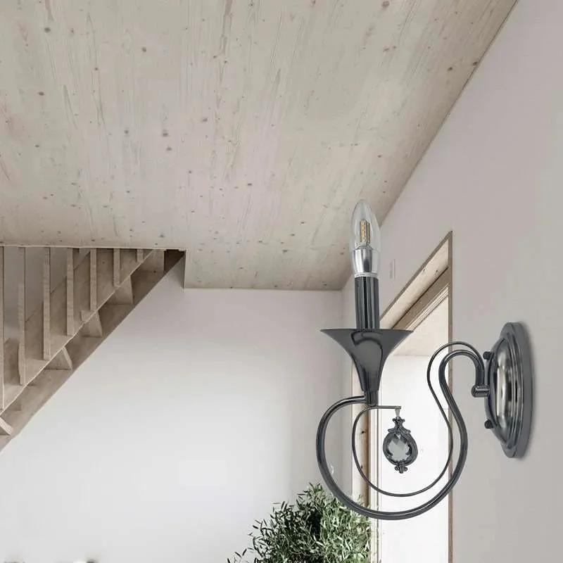 Dimmable candle wall light featuring polished chrome curved arm, circular back plate, and single candle shade.