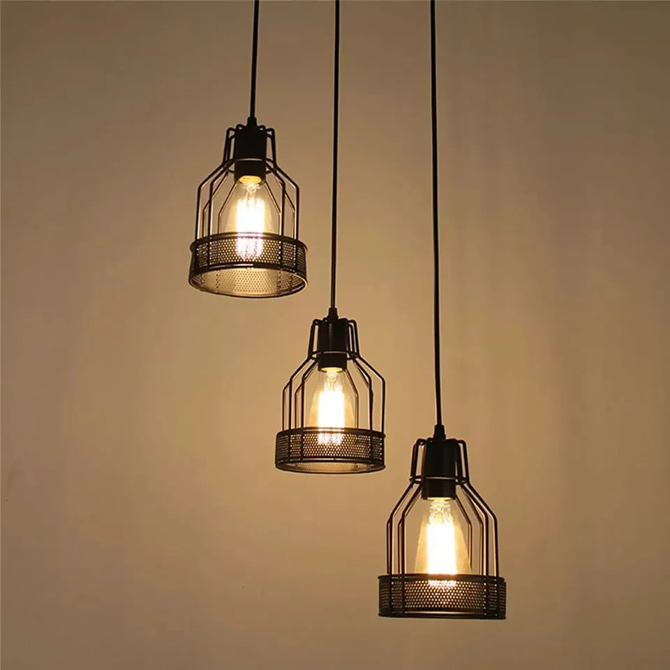 Three black diamond cage pendants hanging on metal cords, each with a black shade, metal frame, and textile cable.