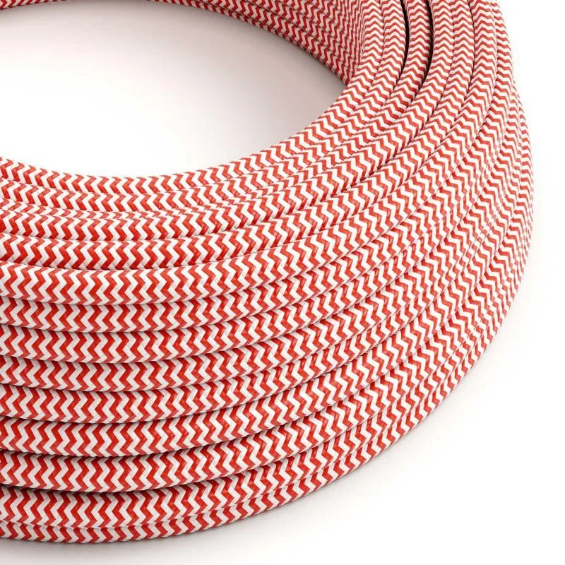 Red and white vintage braided fabric cable laid on white surface, showing 3‑core design and flexible wrap.