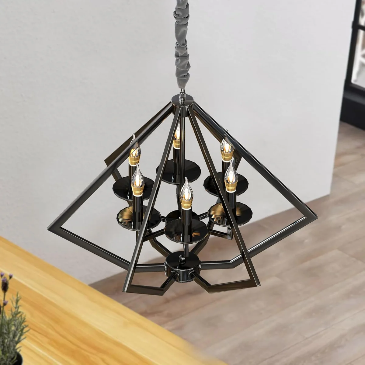 Six-pointed diamond-shaped brushed nickel chandelier hanging from ceiling with adjustable cord.